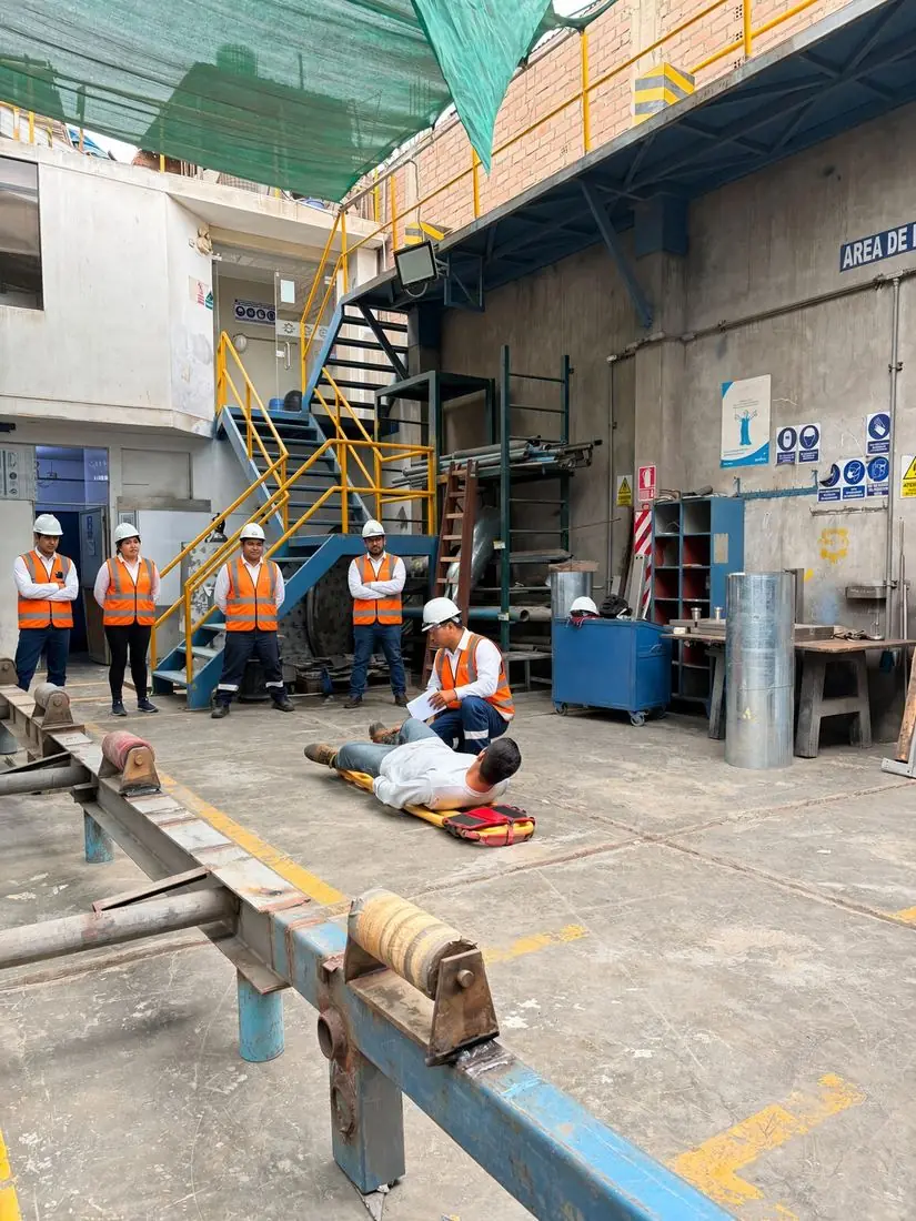 Simulacro de primeros auxilios con camilla en planta industrial